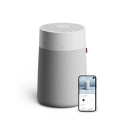 Blueair Blue Pure Max Luftreiniger mit grauem Stoffbezug und Smartphone mit Steuerungs-App daneben