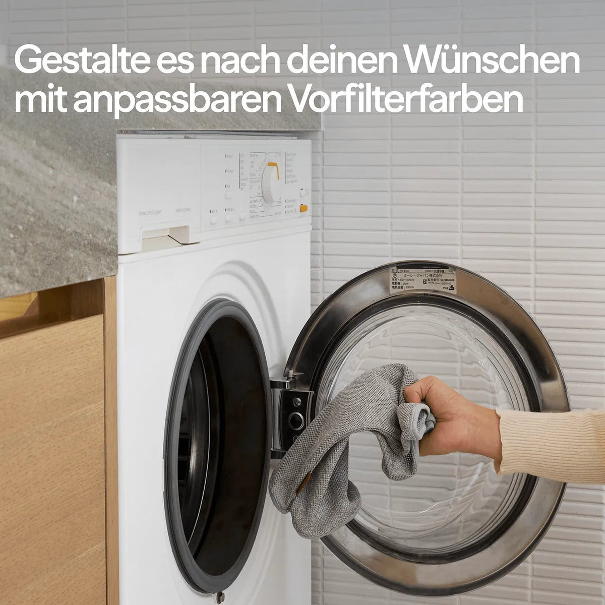 Hand legt grauen Textil-Vorfilter des Blueair Luftreinigers in die Waschmaschine, Werbetext zu anpassbaren Vorfilterfarben
